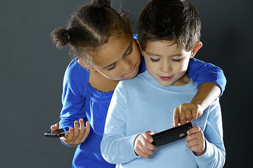 niños usando movil Los niños que miraban fijamente a las tablets